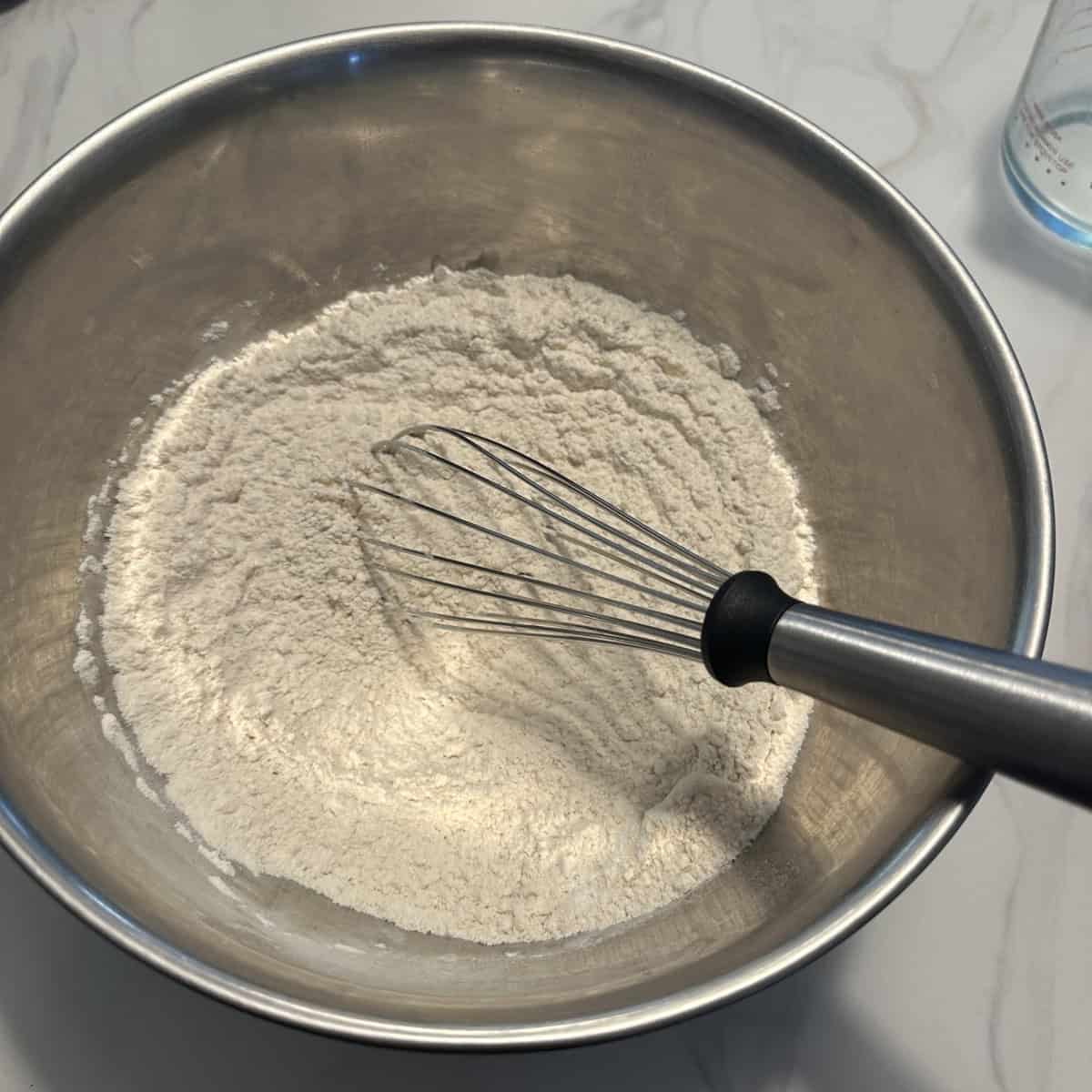 Flour whisked in a large steel bowl.