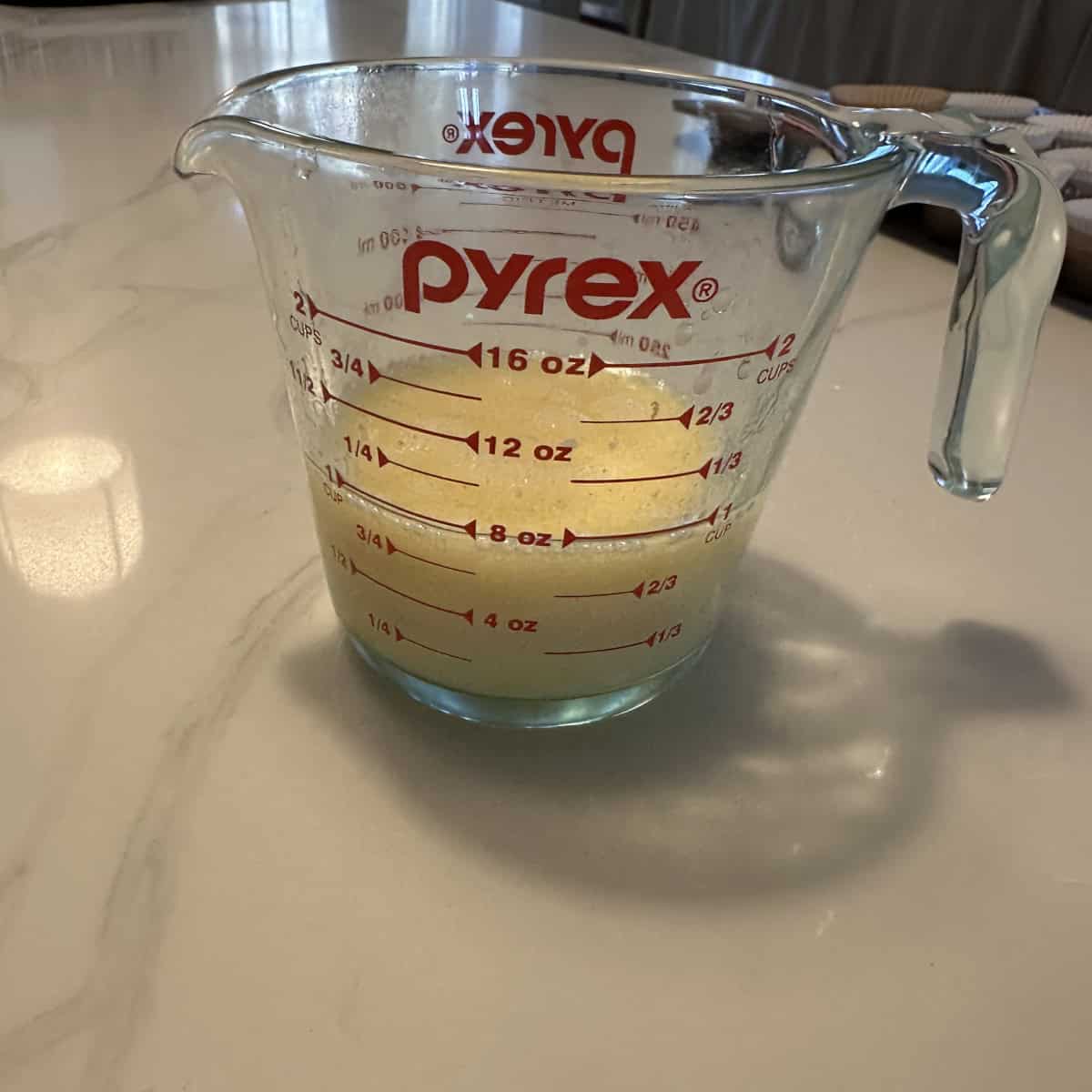 Wet ingredients mixed in a glass container measuring cup.