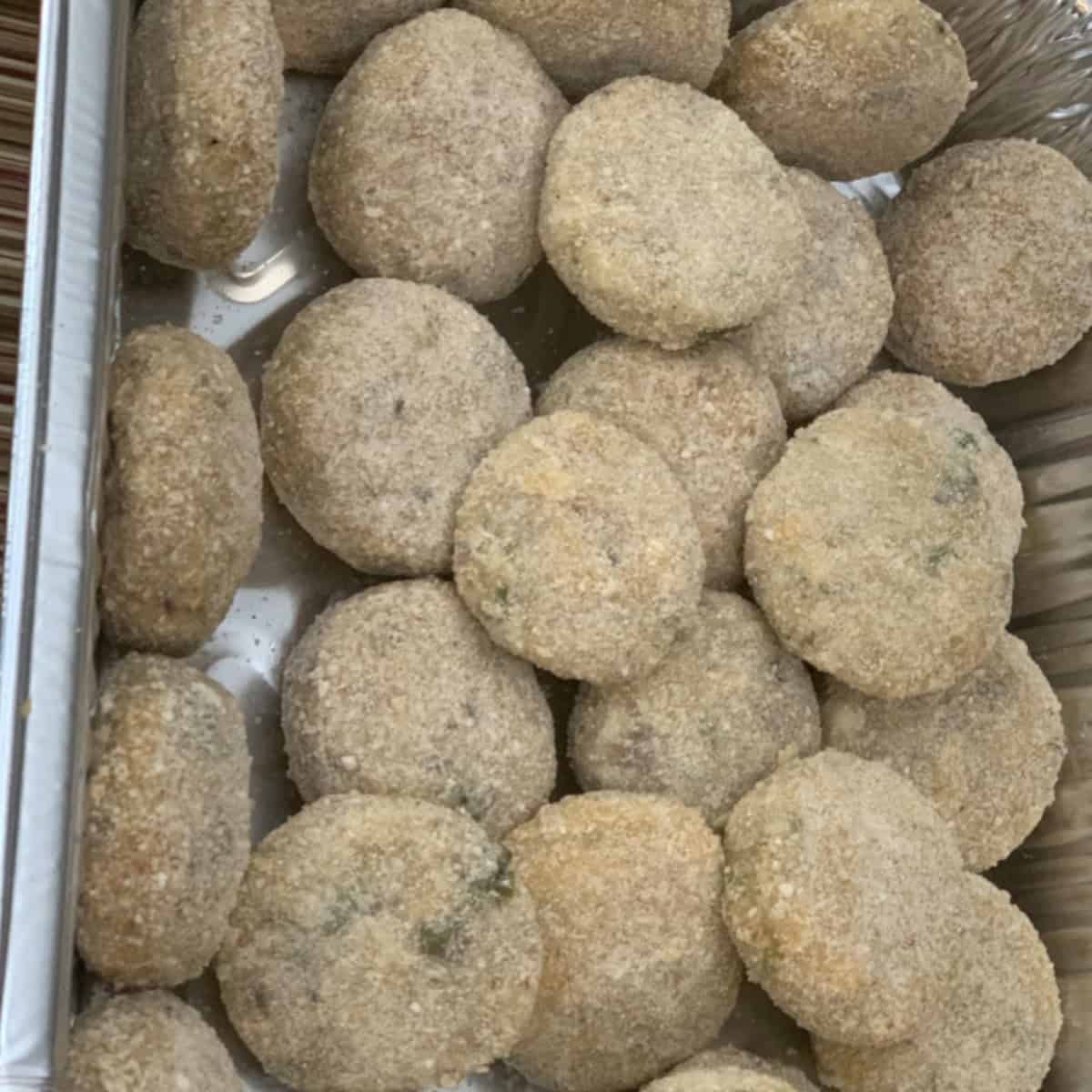 Fish cutlets coated with bread crumbs ready to be fried.