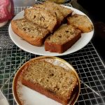 Banana bread with walnuts sliced and served on a white plate.