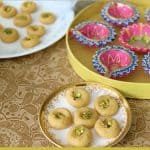 Microwave milk peda in a ceramic plate with lamps or diyas in a yellow box.