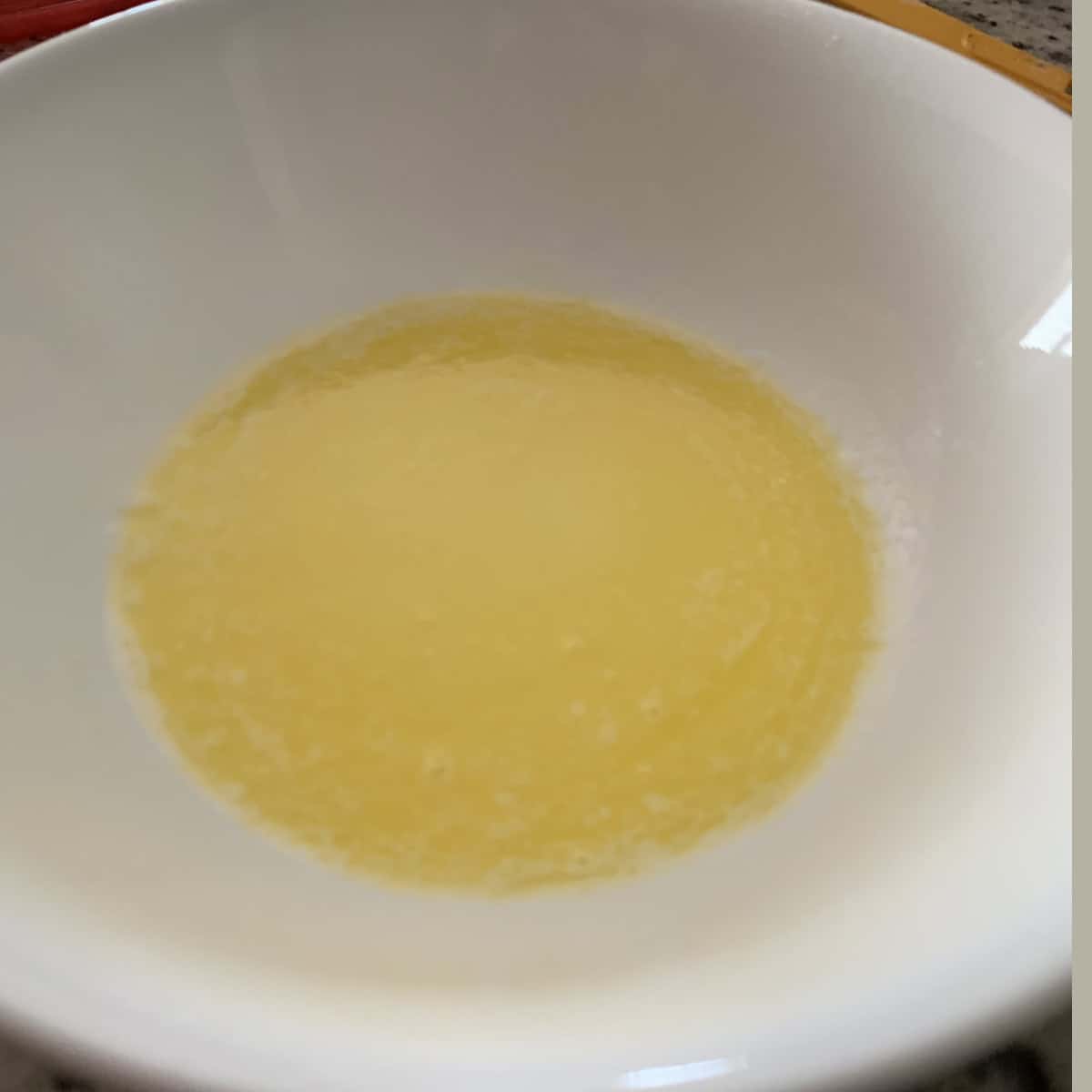 Butter and milk in a white bowl.