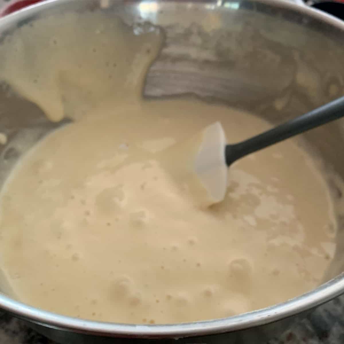 Batter with spatula in a steel bowl and ready to bake