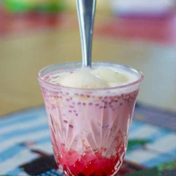 Rose Falooda served in glass with a steel spoon.