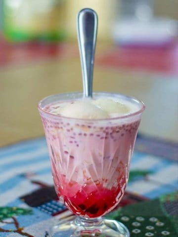 Rose Falooda served in glass with a steel spoon.
