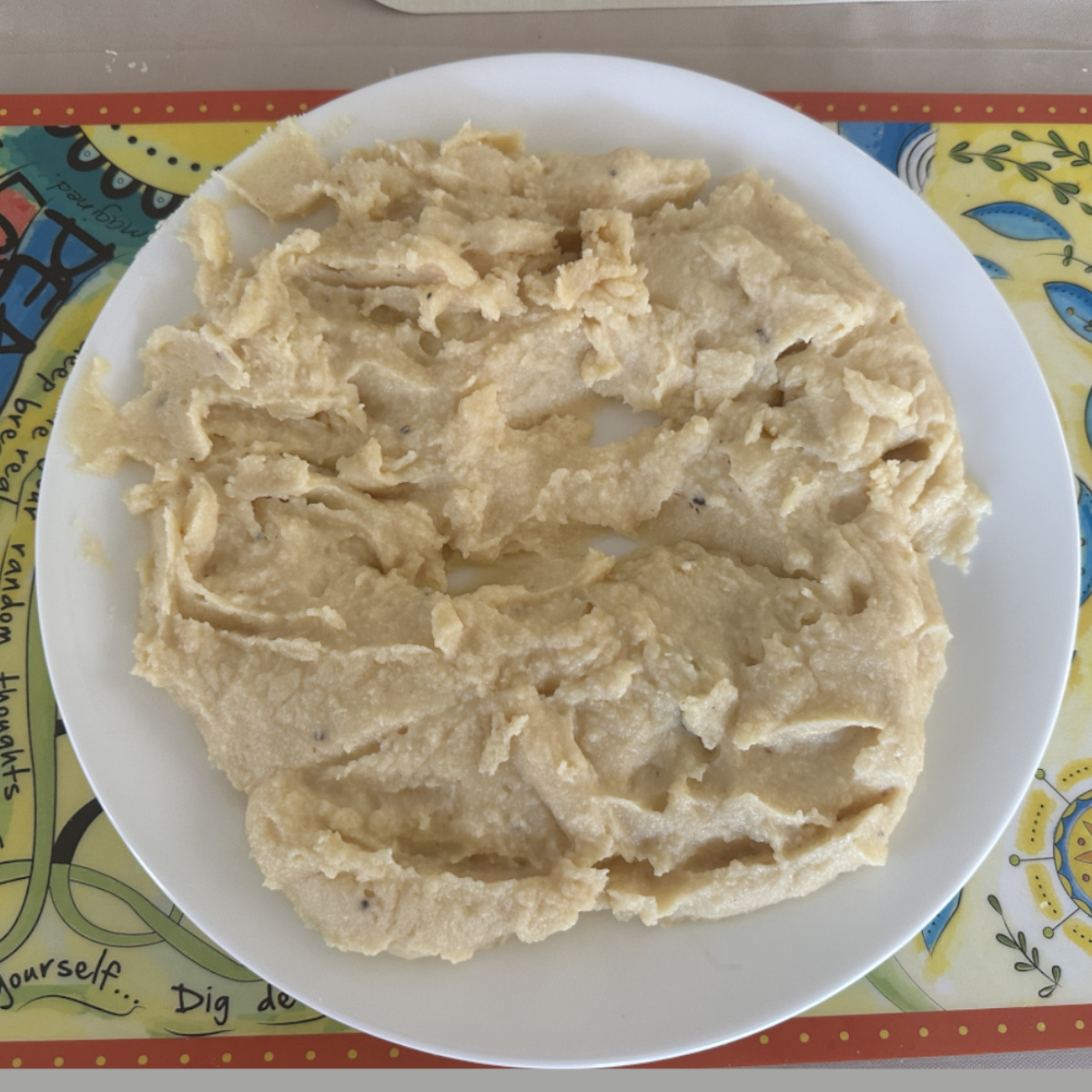 Ricotta cheese peda mixture being cooled on a white plate.