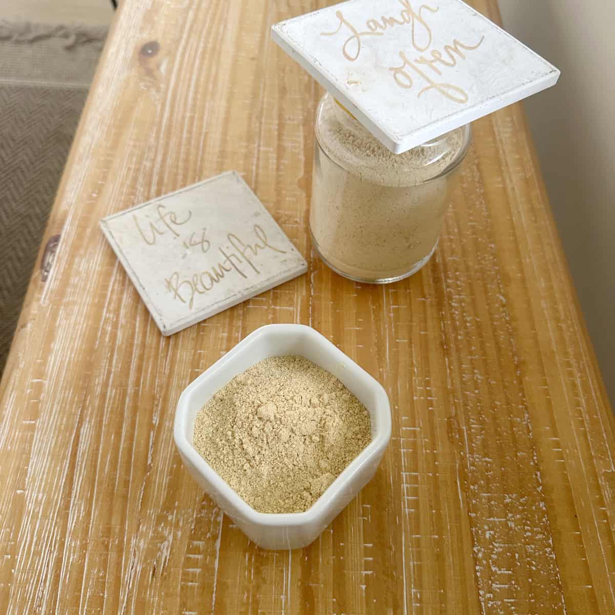 Chutney powder made with Chutney powder recipe in a white bowl and glass container on a wooden board with a tile on the side.
