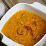 Kerala Prawn Curry with drumsticks in a white serving dish.