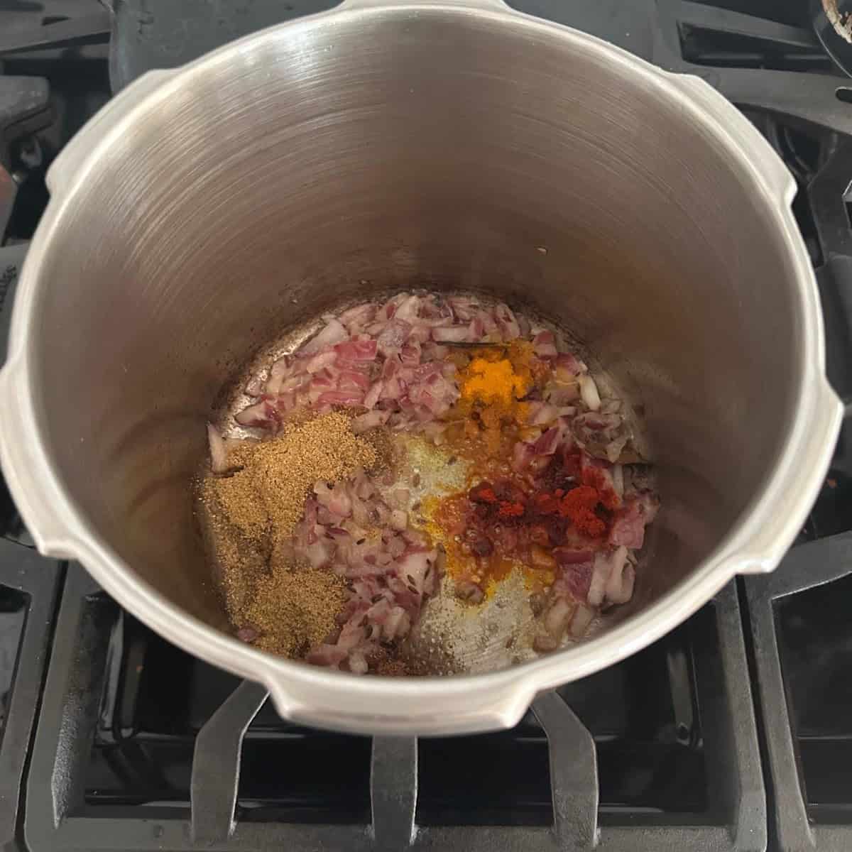 Dry Green Peas Curry base with tomatoes, onions and spices being cooked in a pressure cooker.