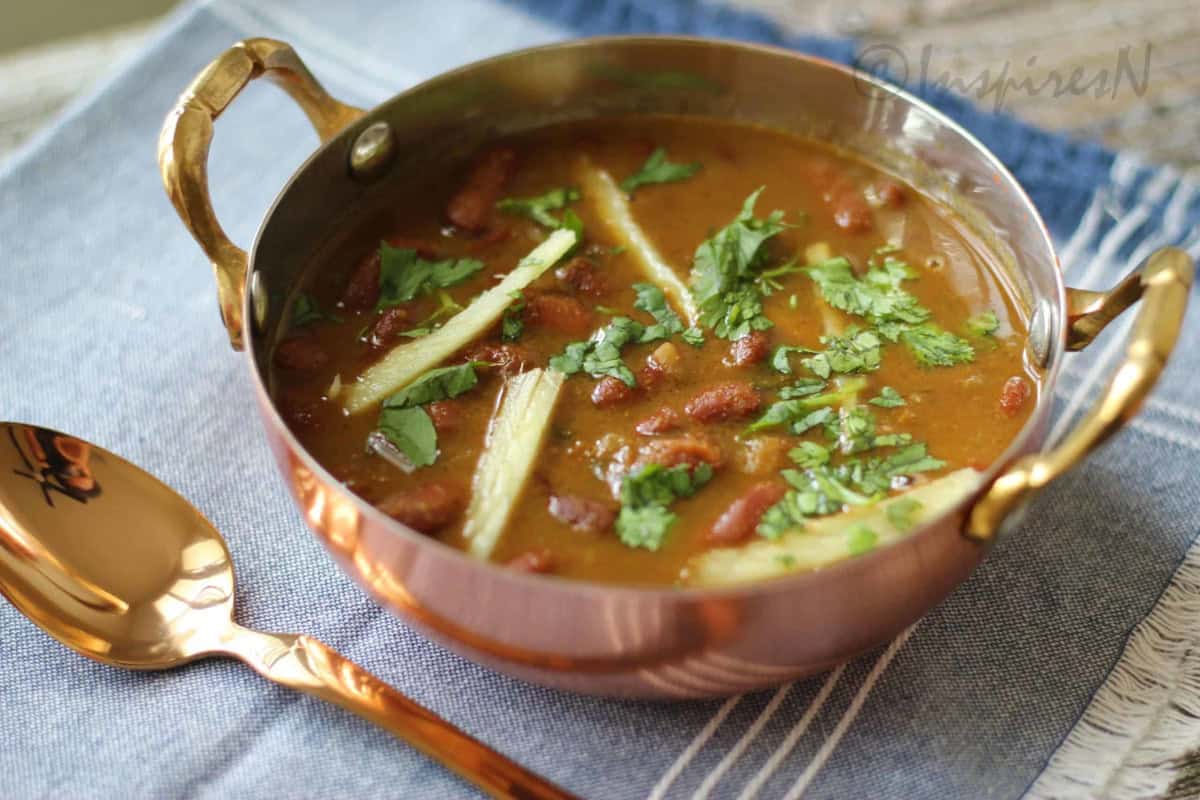 Rajma gravy served in copper vessel with a copper spoon.