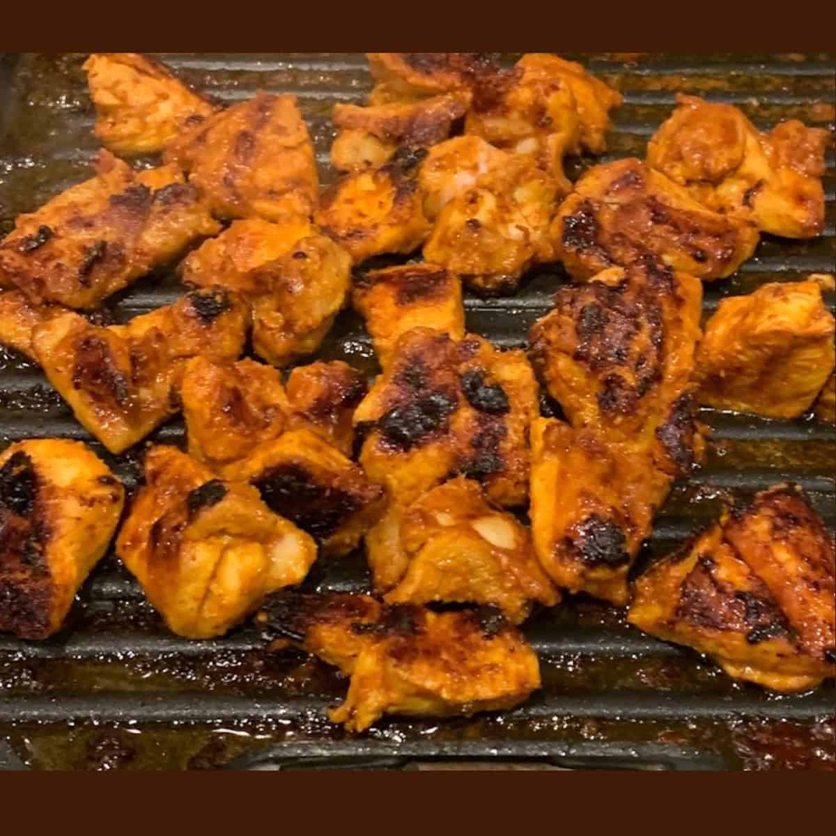 Grilling Chicken on grill pan for making Chicken Tikka Masala Gravy.