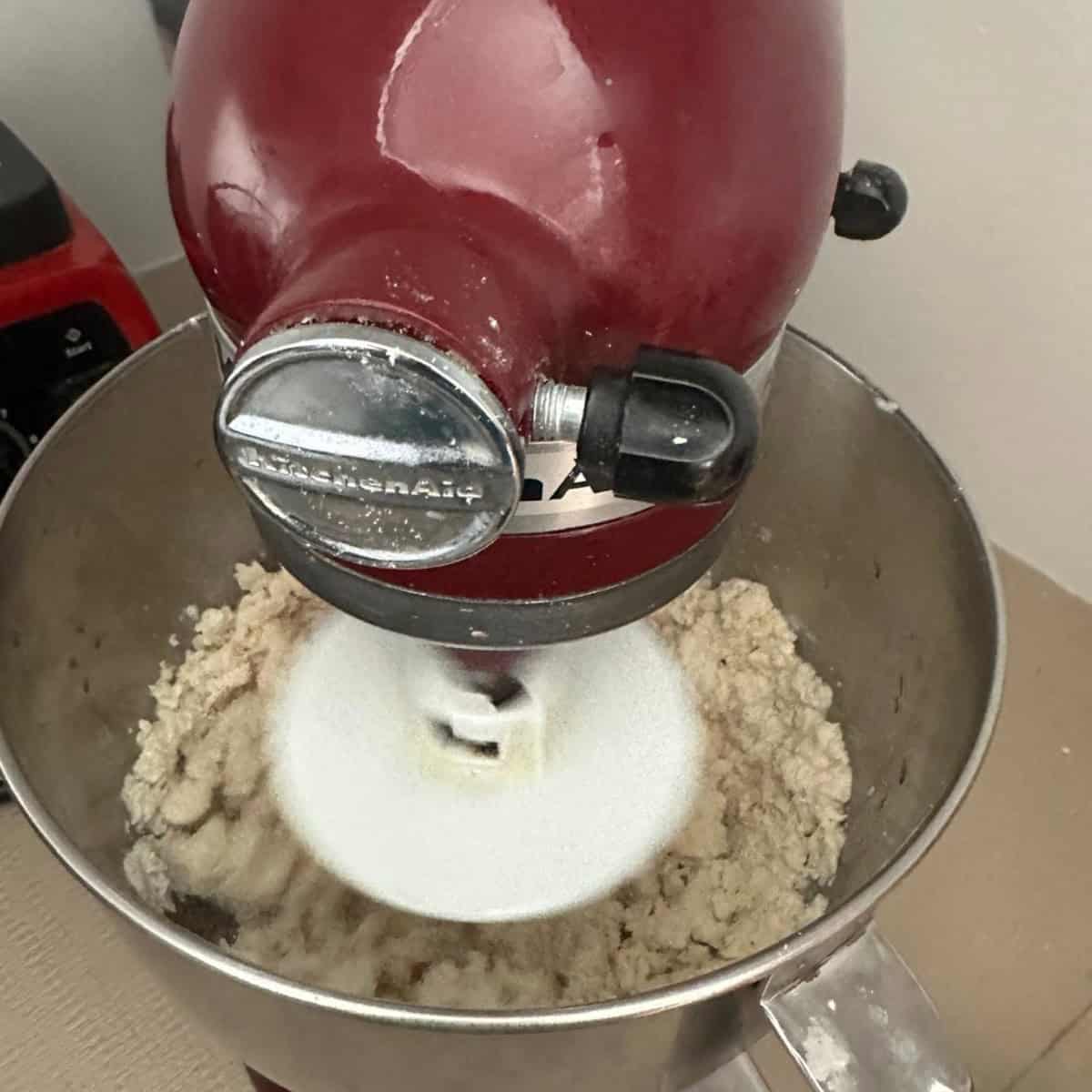 bhatura bread dough being kneaded in a stand mixer.