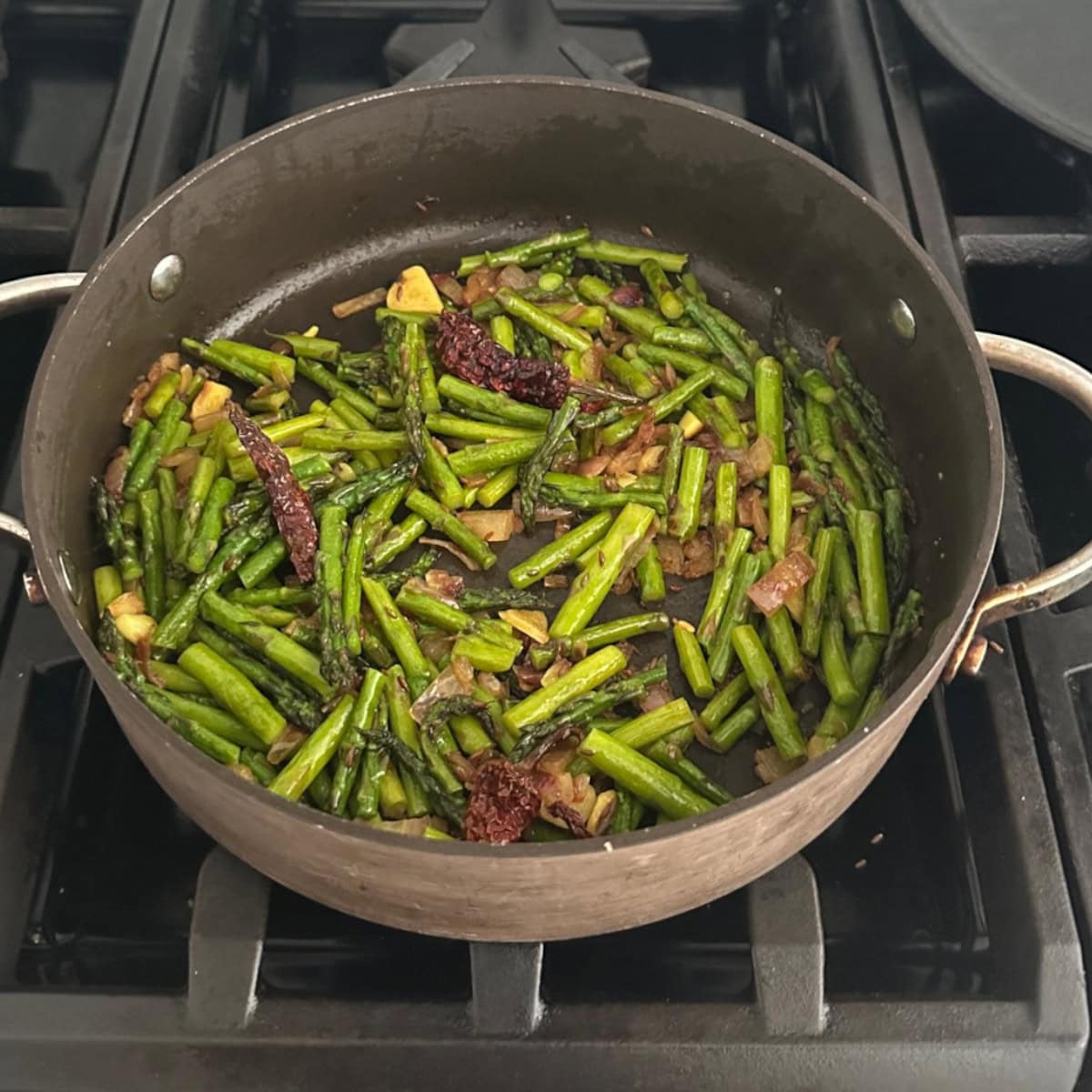 asparagus stir fry cooking in a pan.