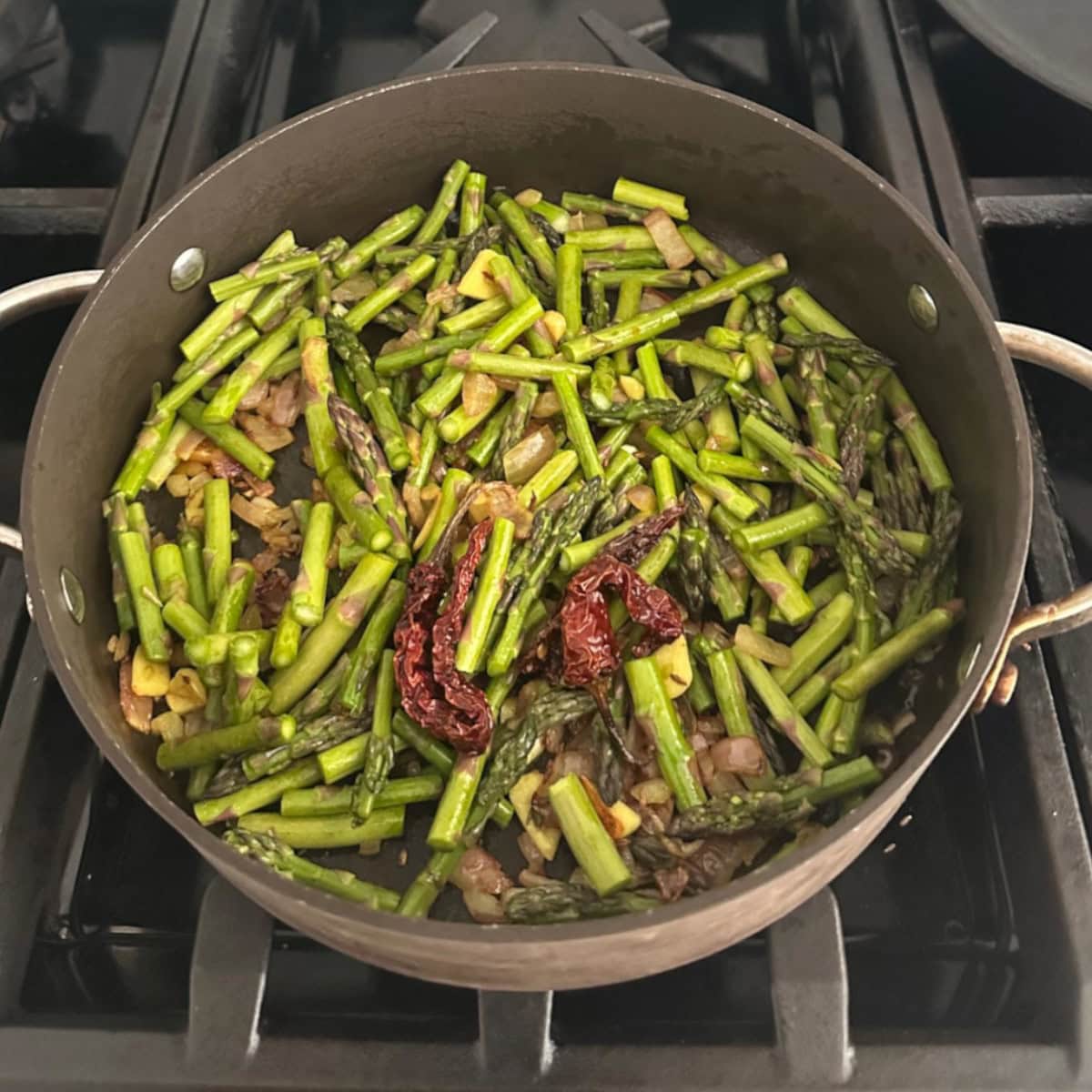 asparagus stir fry cooking in a pan.