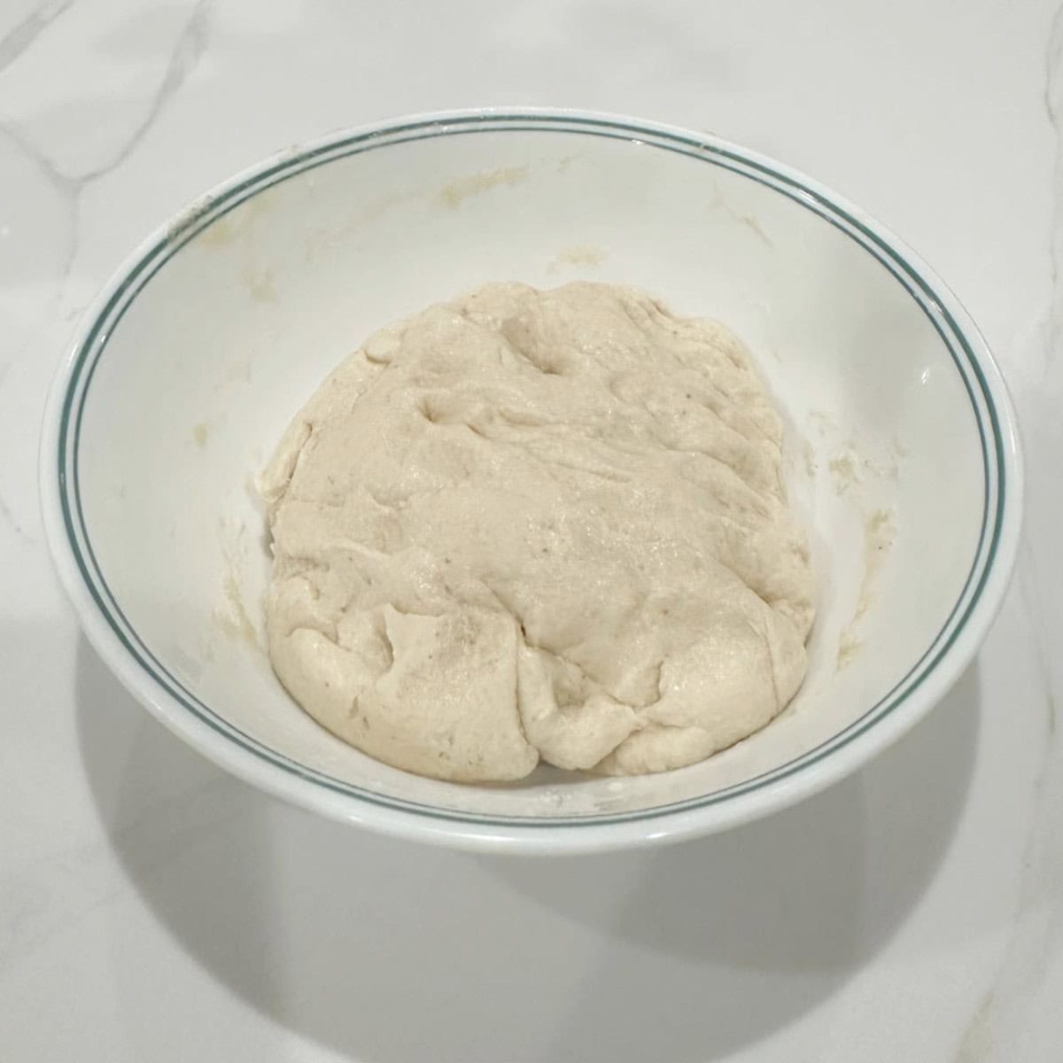 bhatura bread dough rested in a white bowl.
