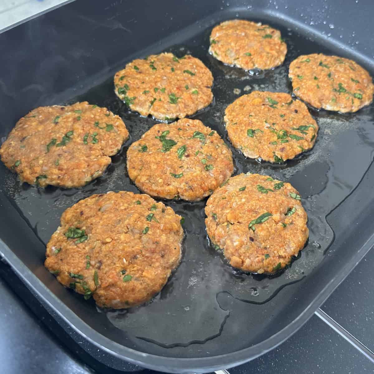 Minced chicken patty cooking.