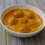 Lauki Kofta served in a white bowl on a wooden board.