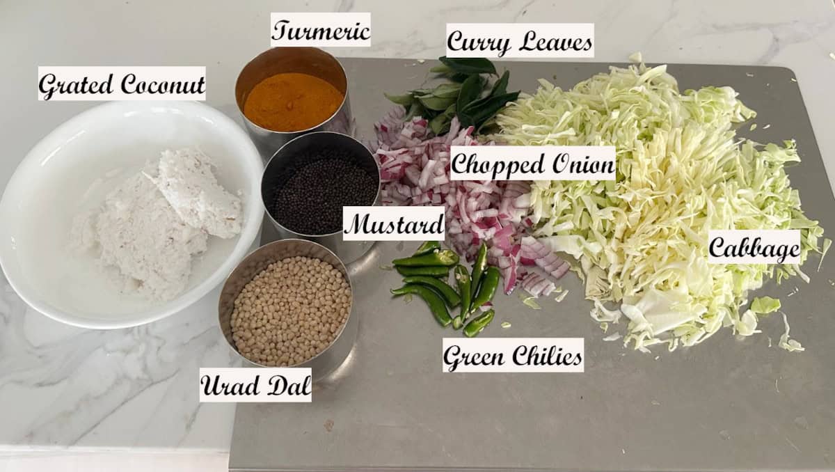 Ingredients to make Cabbage coconut stir fry displayed with ingredient names. on a steel board.