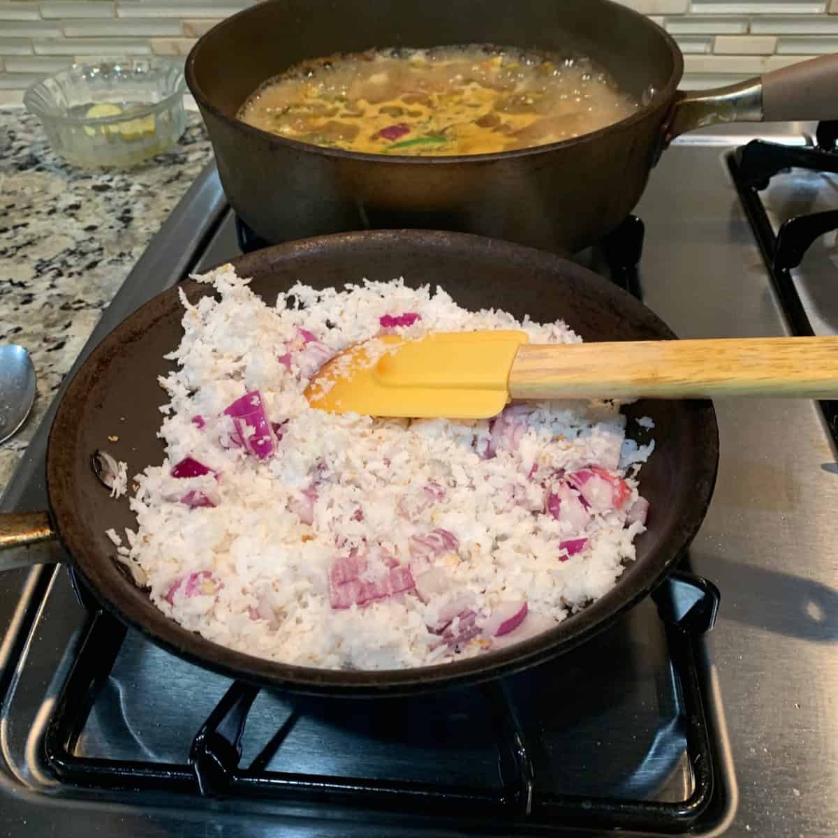 roasting coconut in a black pan.