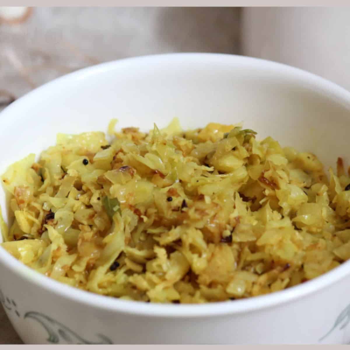Cabbage coconut stir fry in a white bowl.