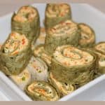Veggie Cream cheese Roll ups served stacked in a white bowl.