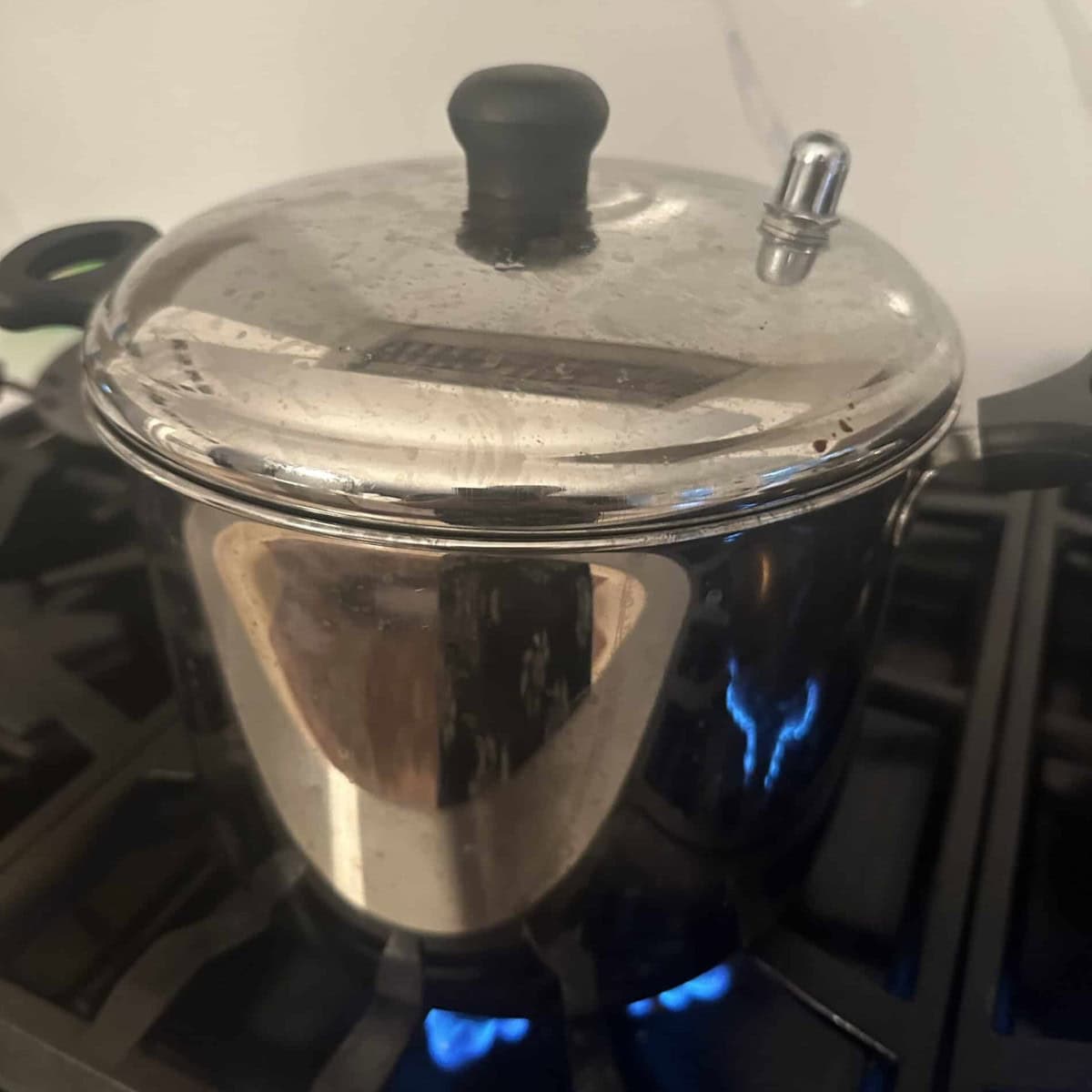 idlis being steamed in a steel idli cooker.