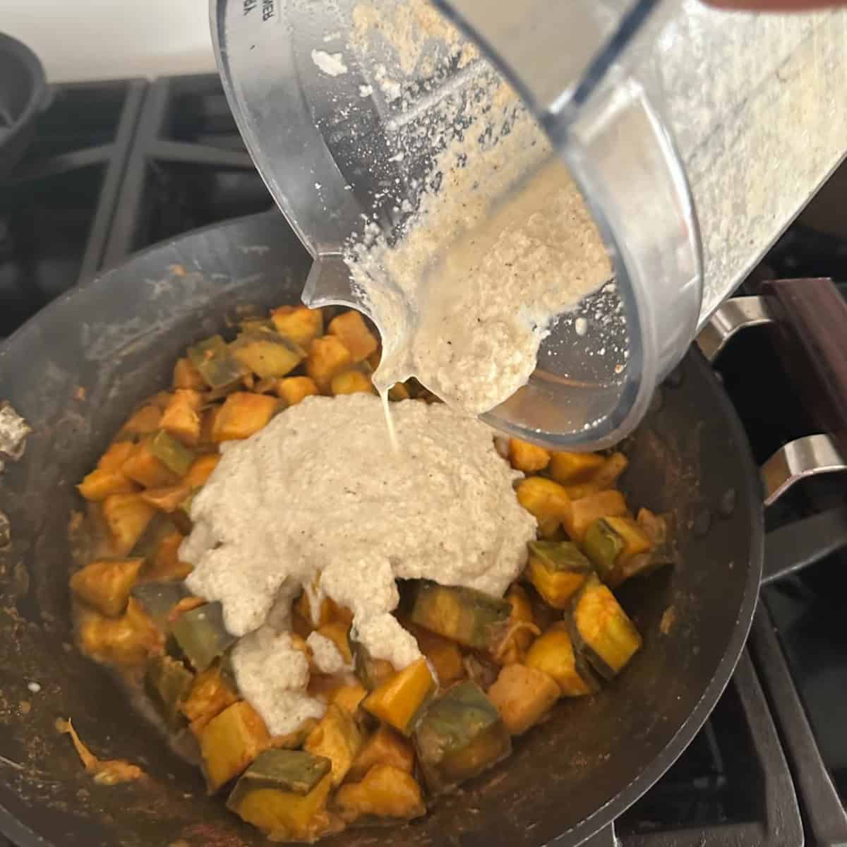 ground coconut being added to kaalan cooked.