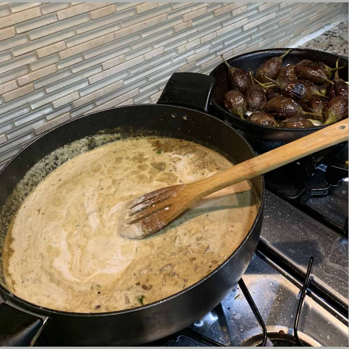 Preparing the sauce for Bagara baingan in a black pan and stirred with a wooden spoon.