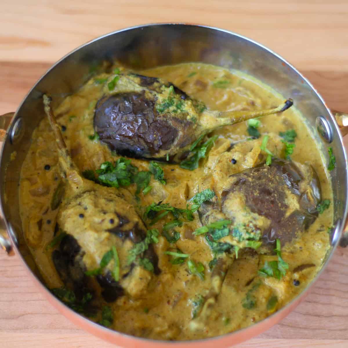 Bagara Baingan (Eggplant in peanut coconut sauce) made with Bagara baingan recipe served in a copper vessel.