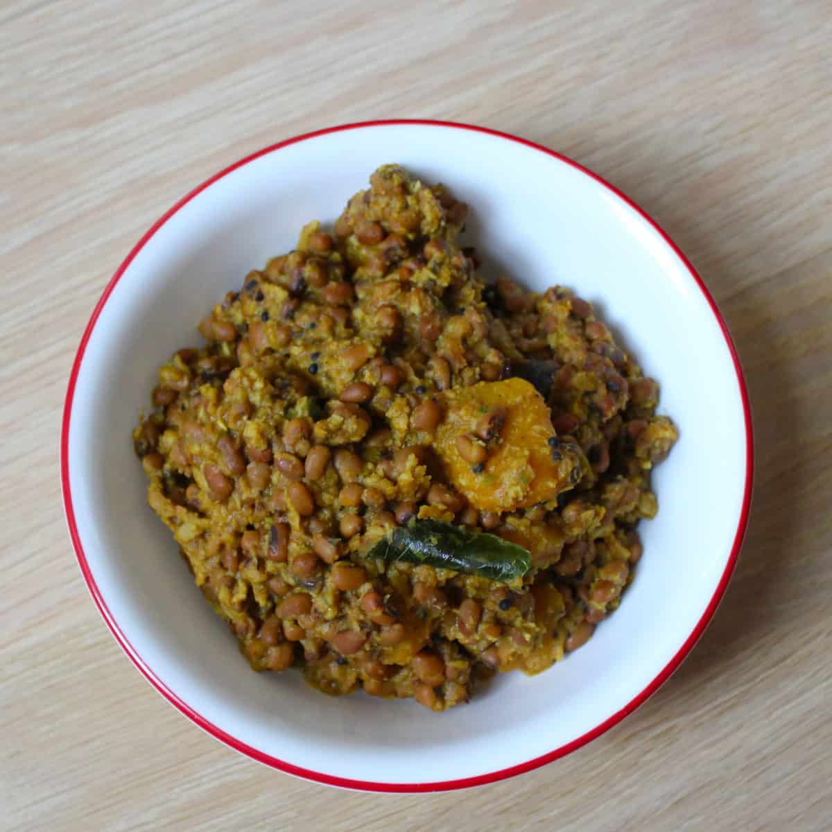Mathanga Errisery in a white bowl on a wooden board.