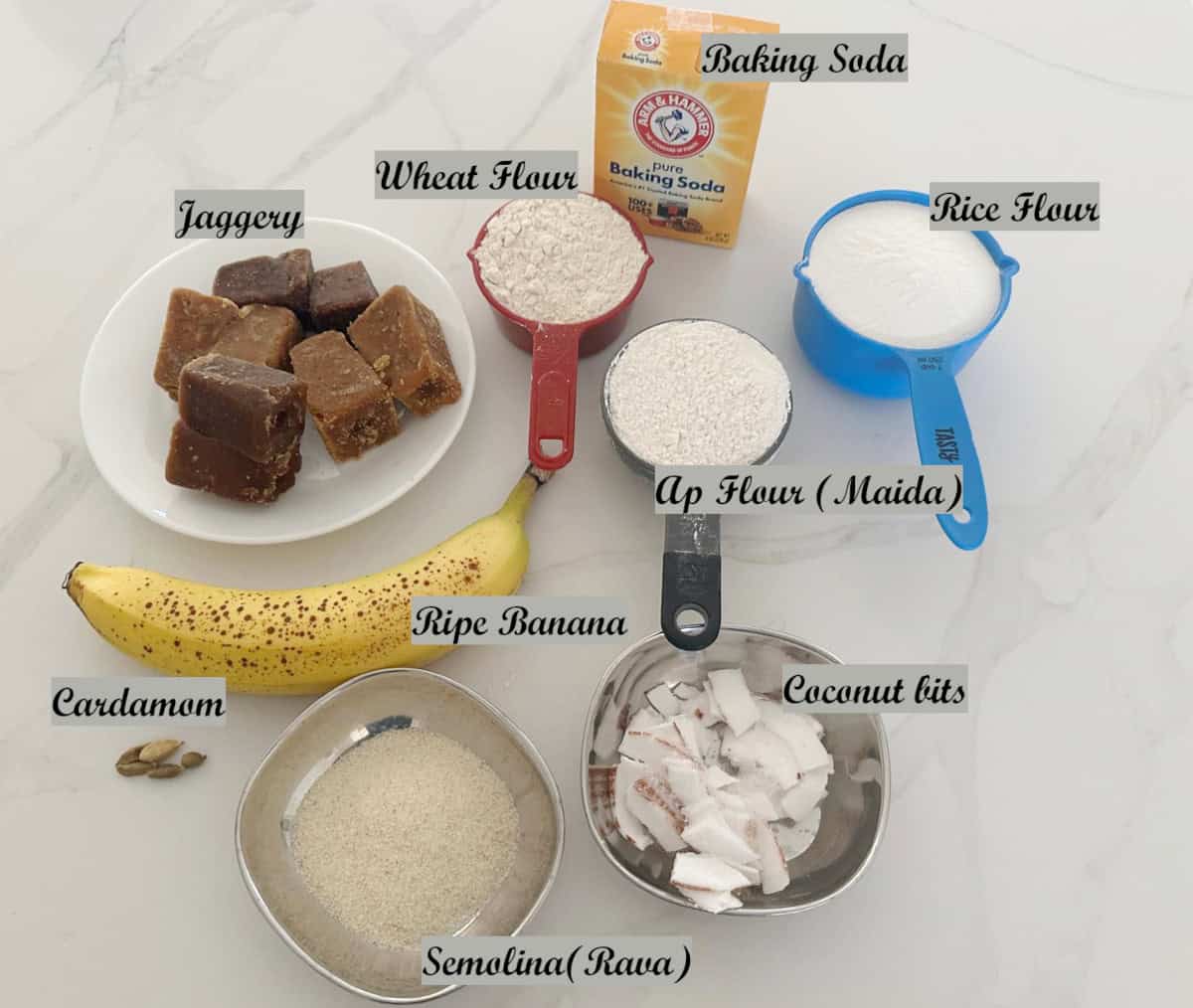 Ingredients to make unniappam displayed on a white counter.