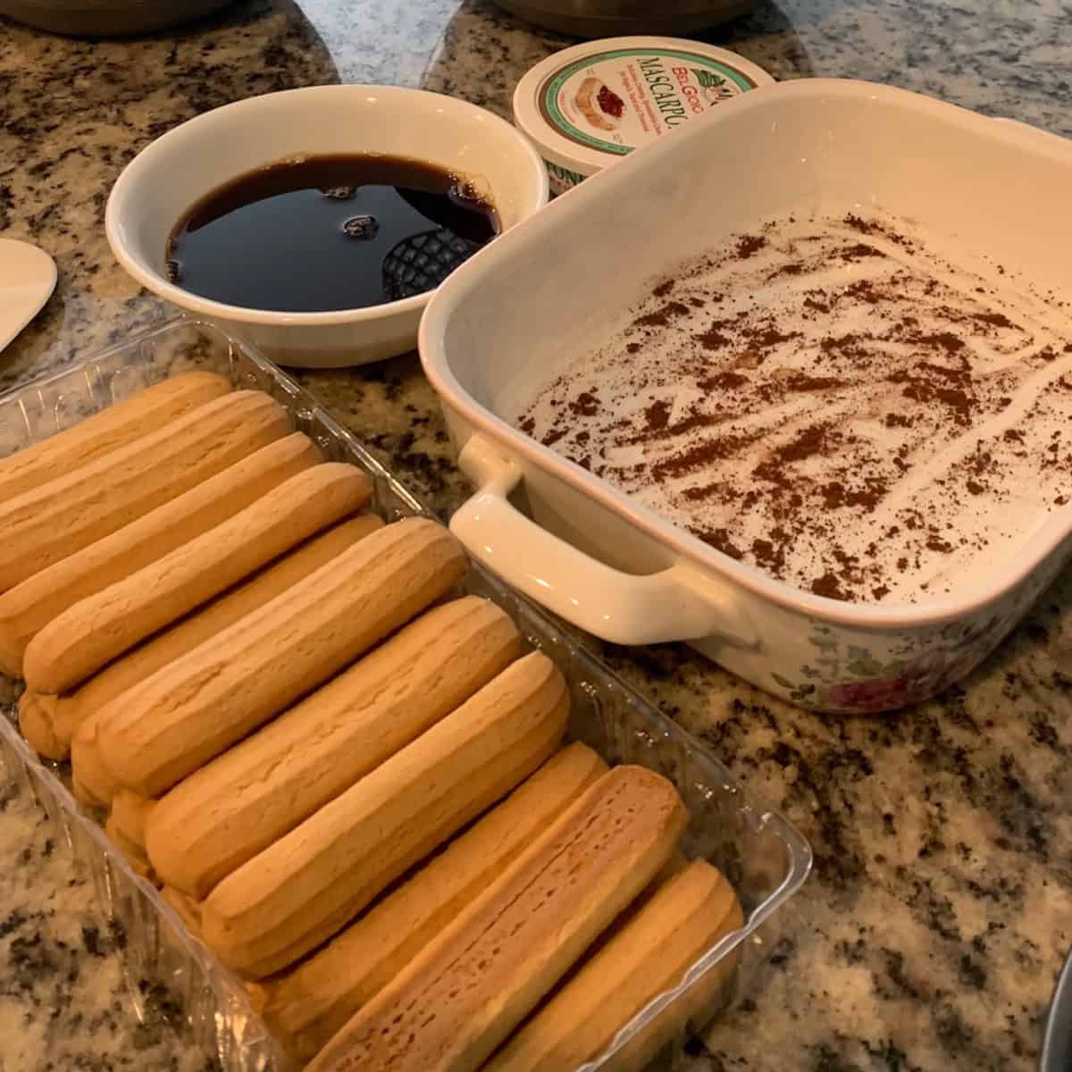 Prepation to make Tiramisu with a dessert bowl, lady fingers and coffee.