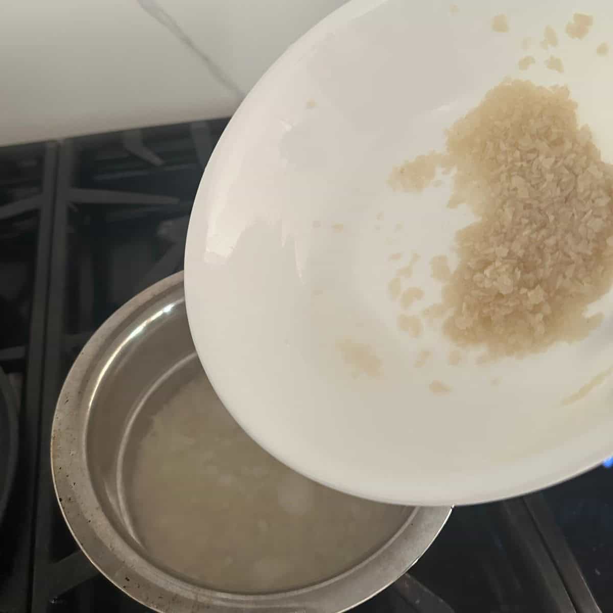 washed palada being transferred to a bowl of hot water.
