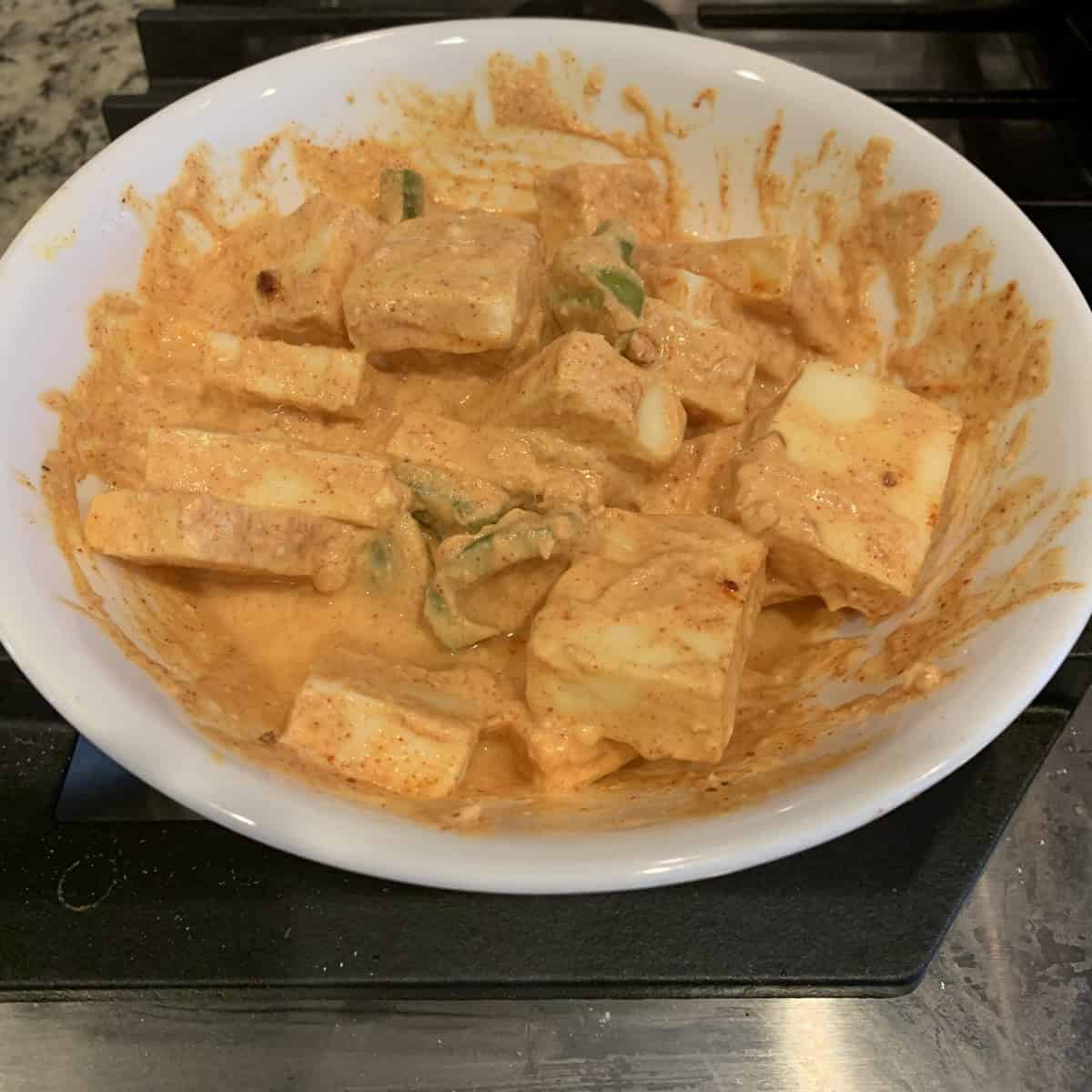 paneer marinated in a white bowl.