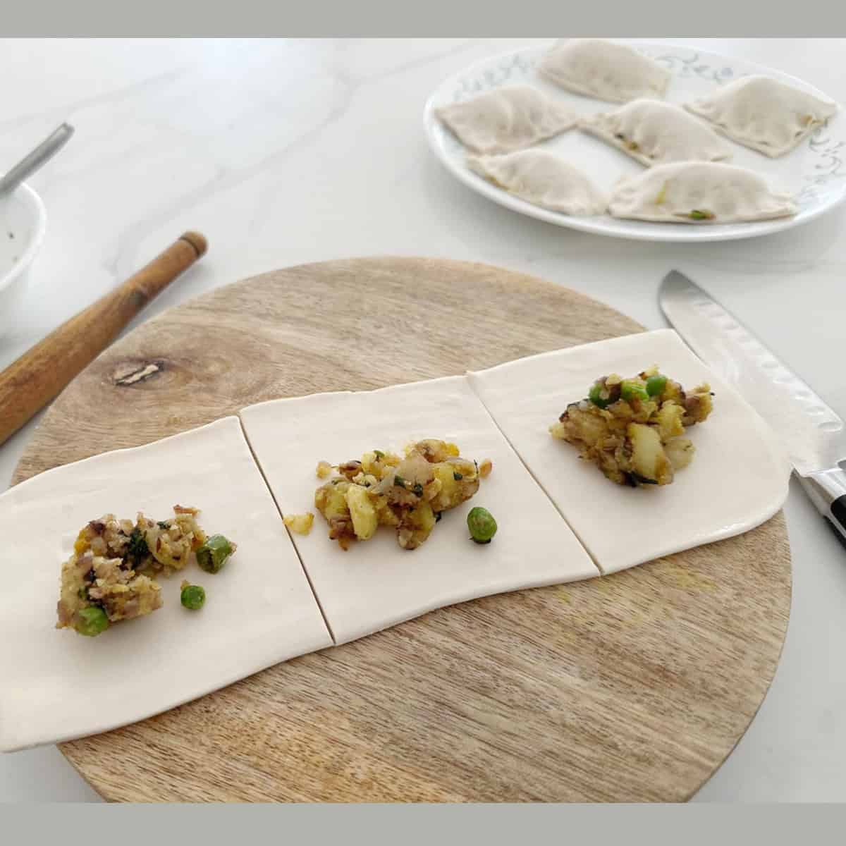 pastry sheets being filled with vegetable filling.