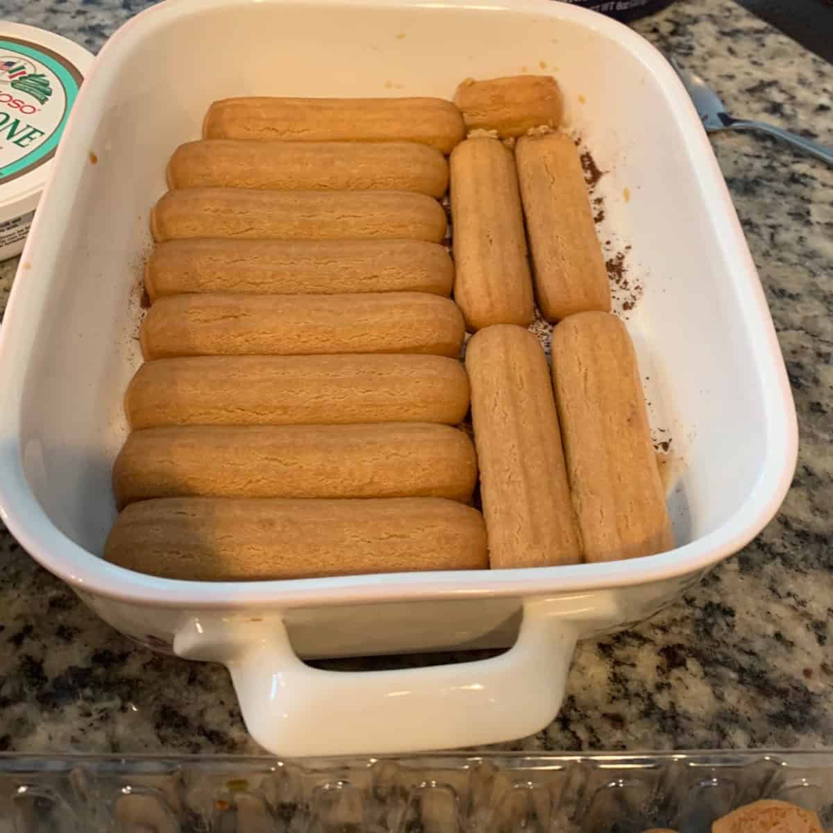 layering soaked ladyfingers in a dessert bowl.