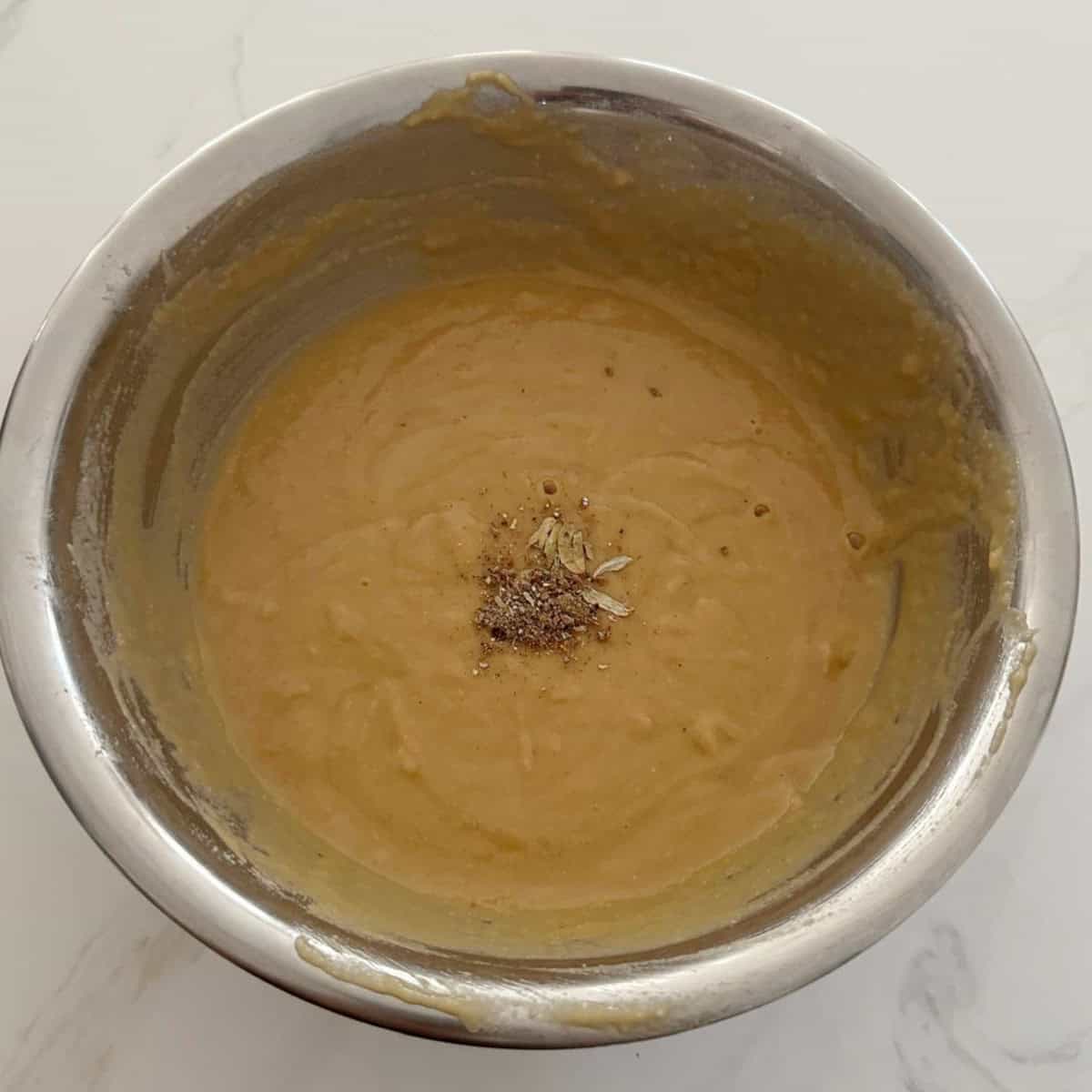 powdered cardamom being added to unniappam batter.