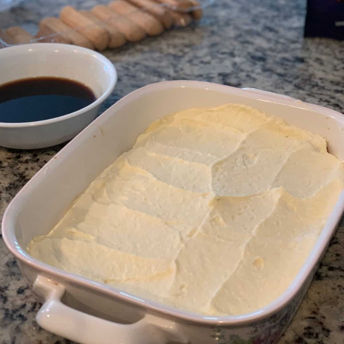 Tiramisu layering in a white casserole.