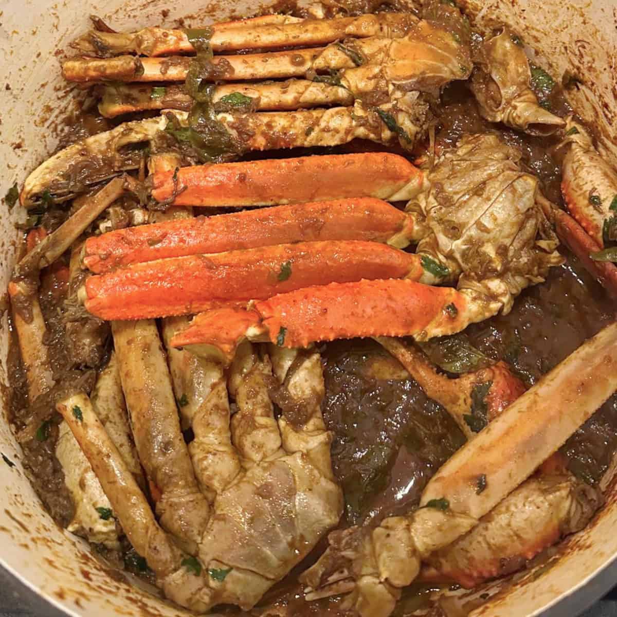 crabs cooked in a spicy gravy in a cast iron pot.