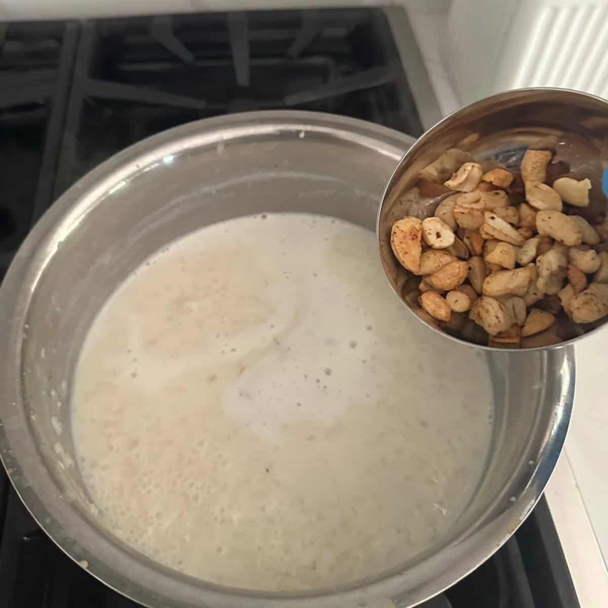 fried nuts and raisins being added to payasam.
