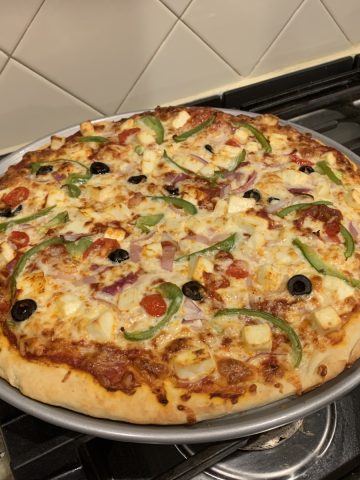 vegetarian pizza baked in a pizza pan ready to serve.