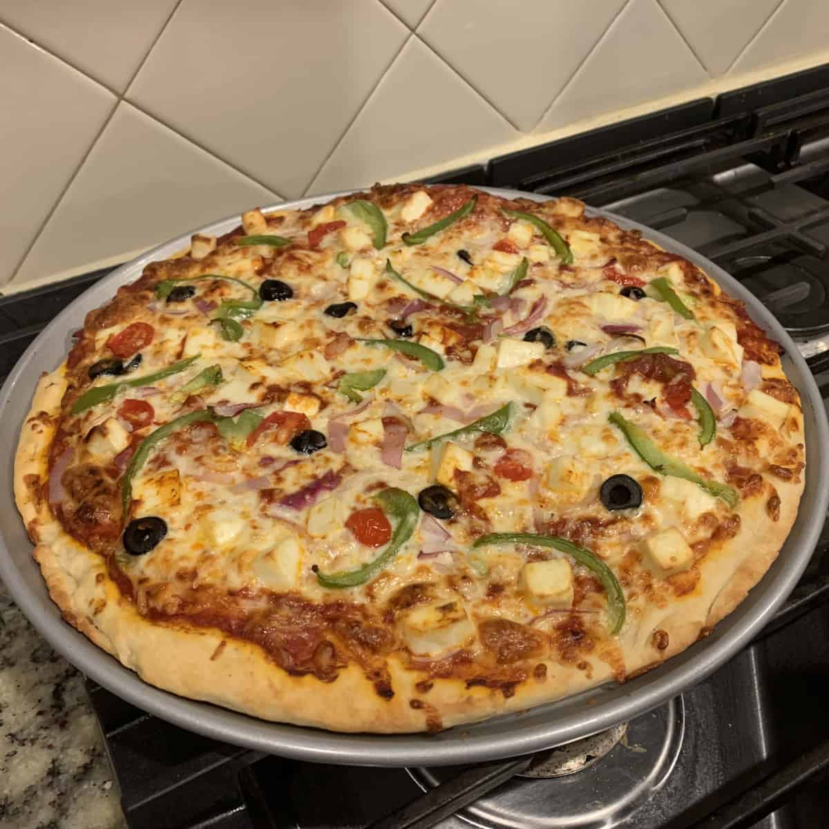 vegetarian pizza baked in a pizza pan ready to serve.