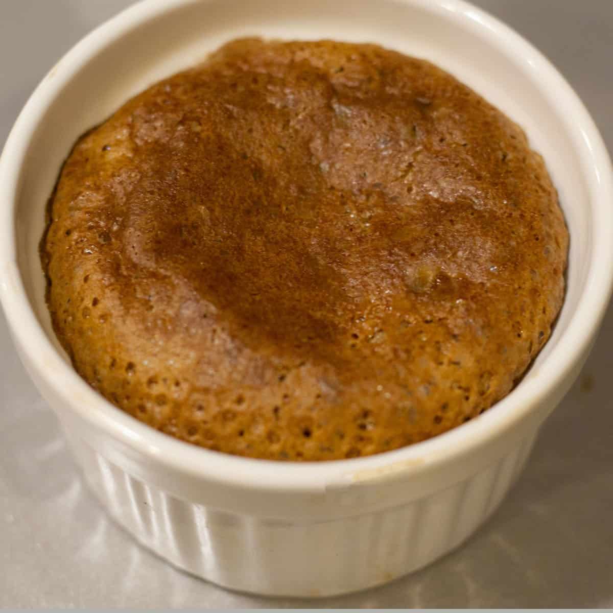 Hot choco lava cake in a white ramekin.