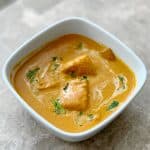 Paneer Tikka Masala Restaurant Style in a white bowl garnished with coriander leaves and cream.
