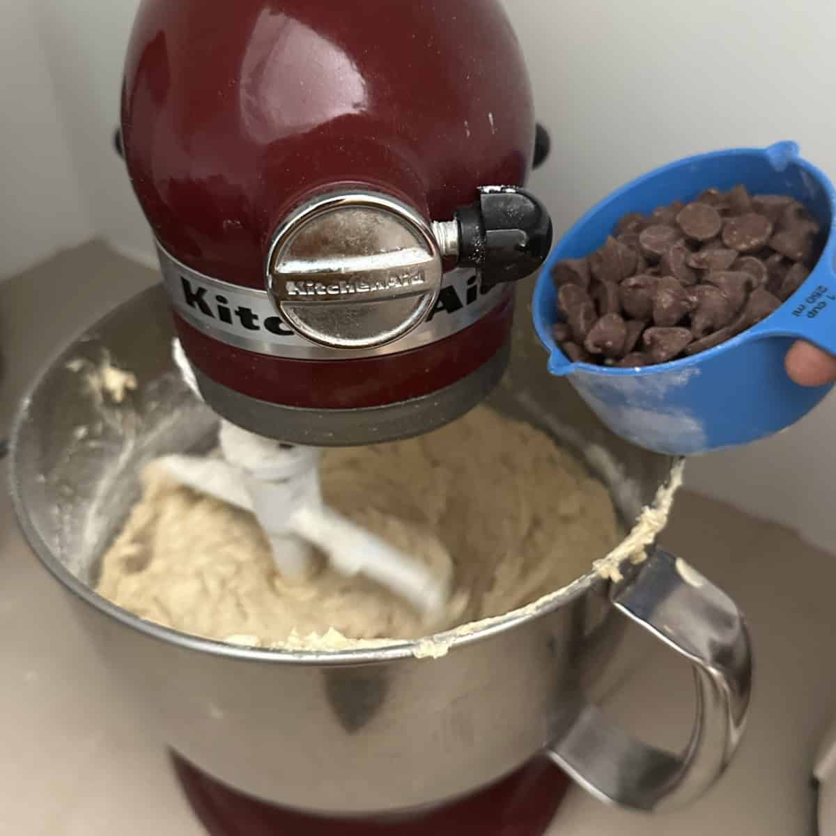 Adding chocolate chips to almond flour cookie batter.