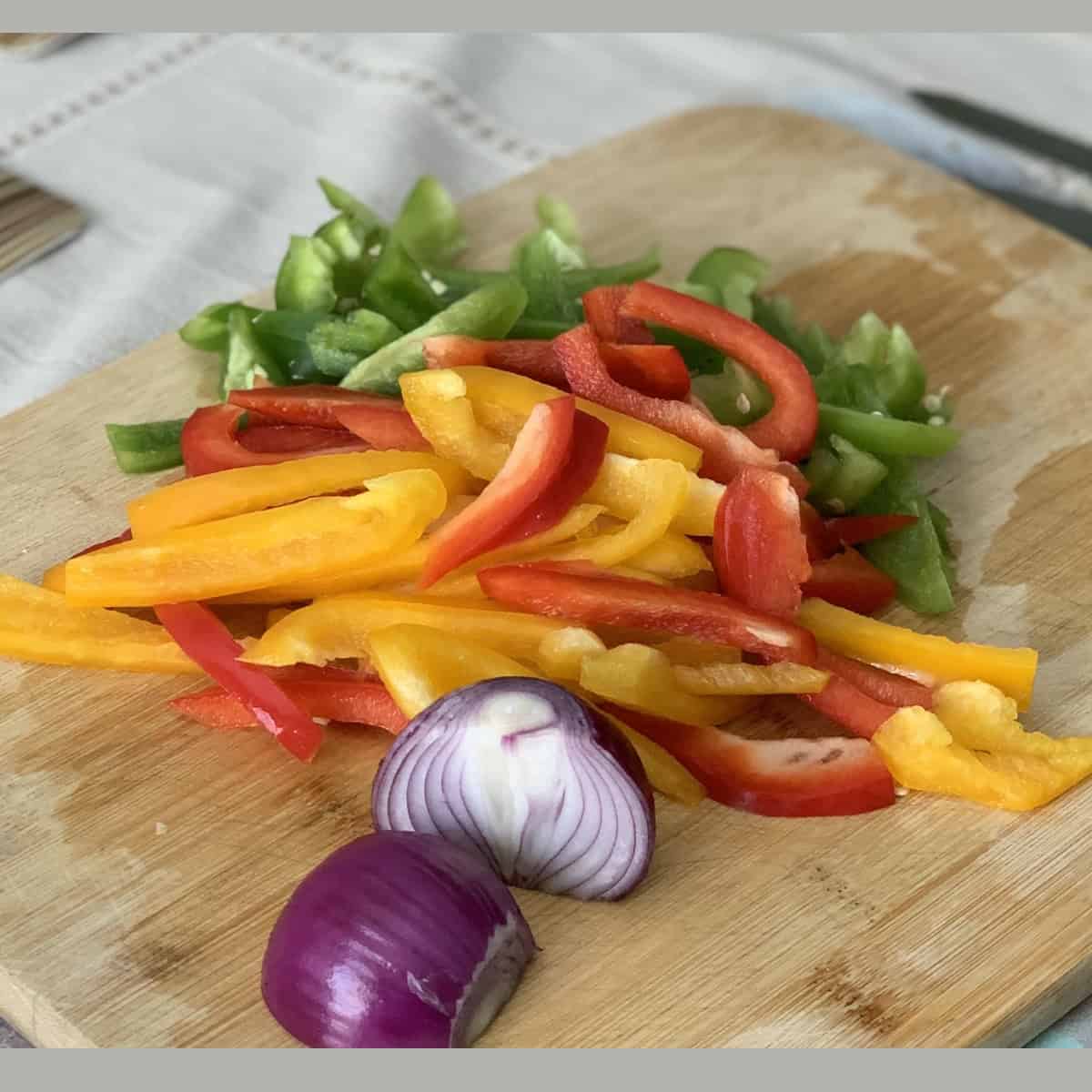 chopped veggies on wooden cutboard.