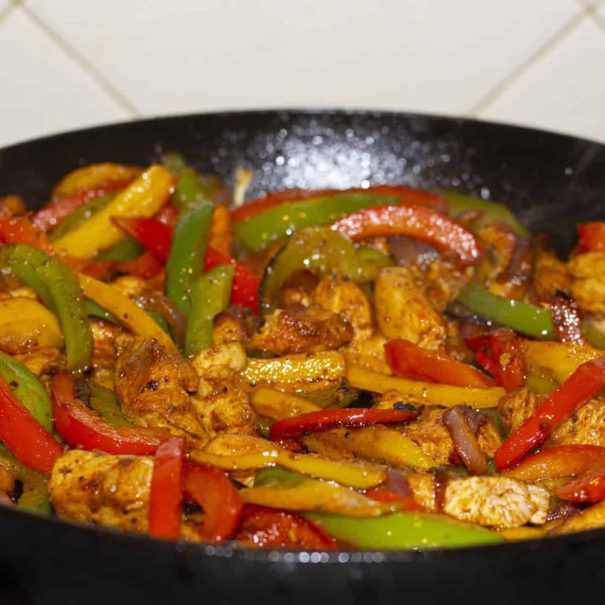 veggies being sauteed in a cast iron skillet.