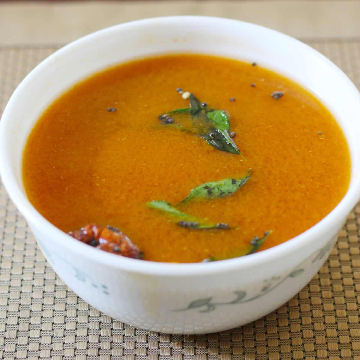Rasam served in a white bowl.