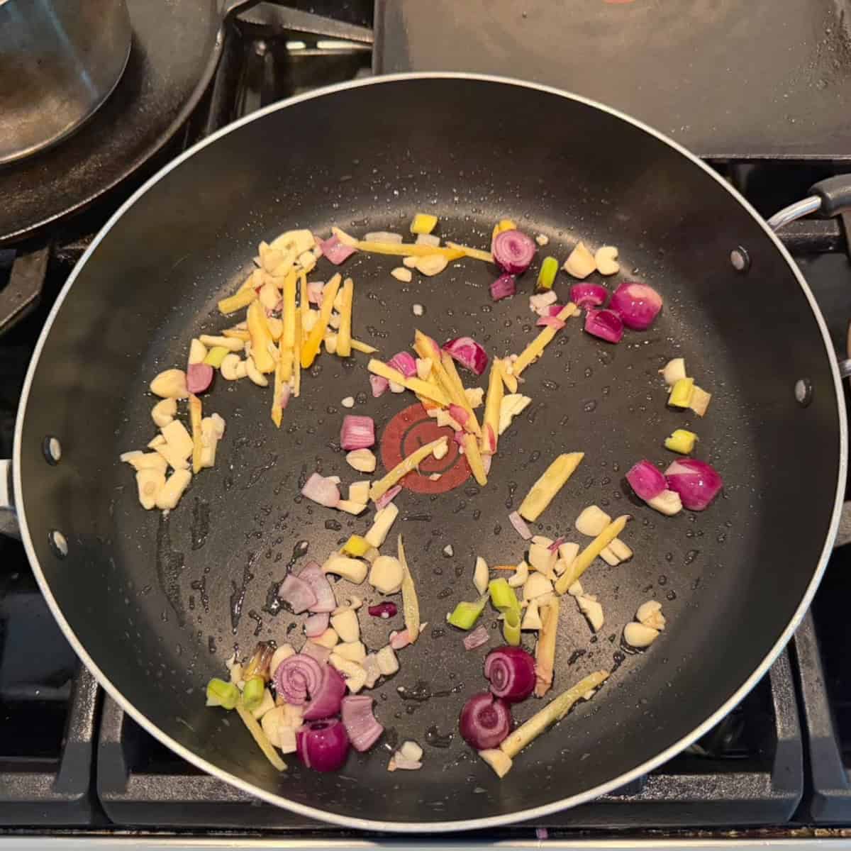 veggies sauteed in a black pan.