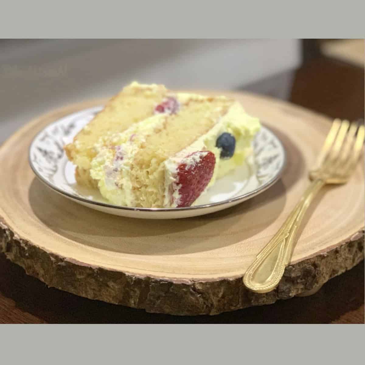 Best Tres Leches served in a dessert plate on a wooden board.